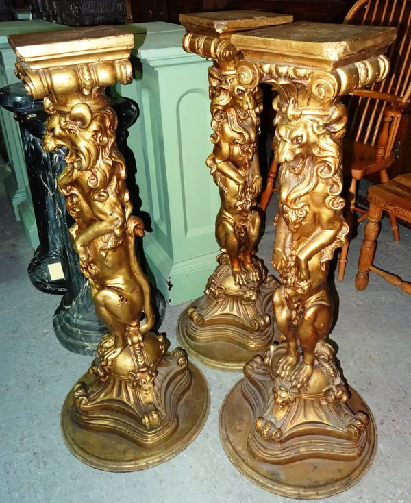 A group of three 20th century gold painted heraldic style jardiniere stands, with carved lion central column and plinth base, 23cm wide x 110cm high,