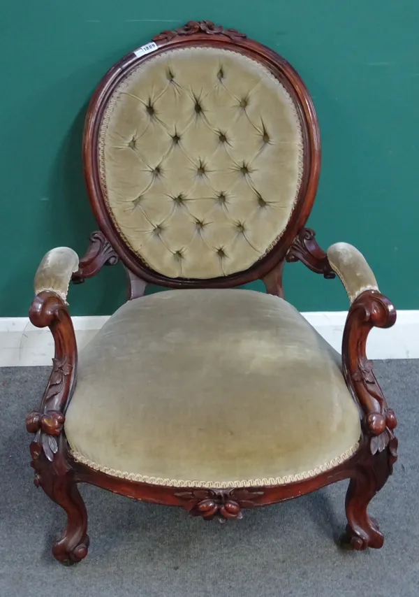 A Victorian carved rosewood framed easy chair, with oval back and open arms, on scroll supports, 70cm wide x 92cm high.  L6