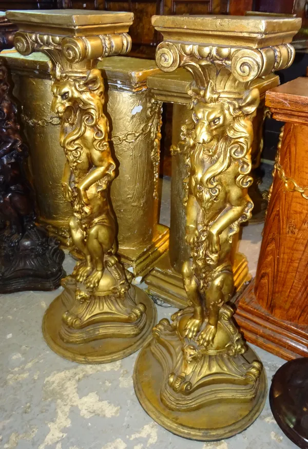 A pair of 20th century heraldic style gold painted jardiniere stands, with carved lion central column, 23cm wide x 112cm high, (2).  M8