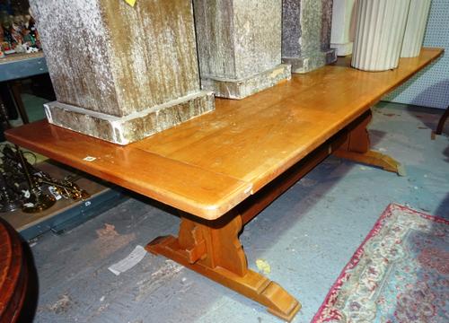 A 20th century oak refectory dining table, on trestle end supports united by stretcher, 246cm wide x 79cm high.  E1
