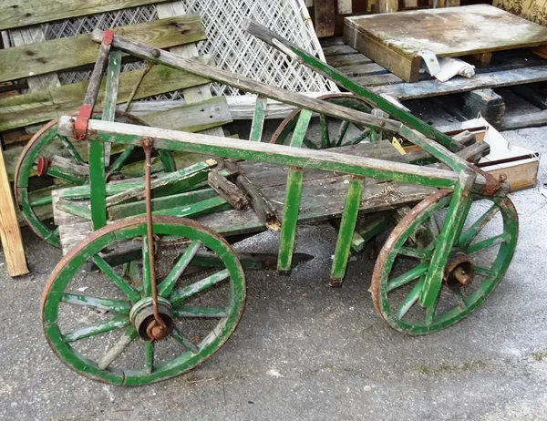 An early 20th century green painted dog cart, 97cm wide x 68cm high.  OUT