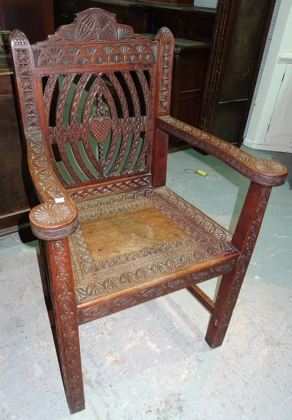 A 19th century Anglo Indian hardwood carved open armchair, with splat carved back, on square block supports.  H10