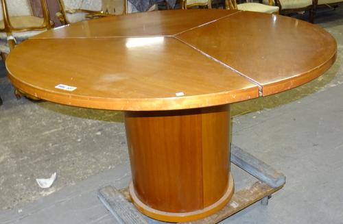 Skovby SM32 Kirseber, Denmark; a 20th century teak extending dining table, the segmenting circular top receiving three spring loaded extra leaves, 120