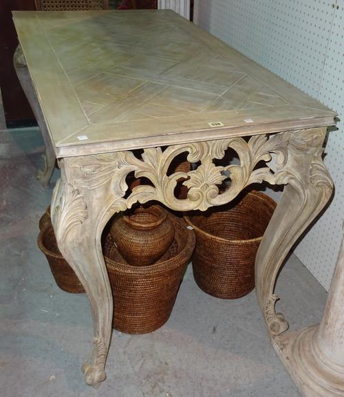 A George II style stained pine centre table, with floral foliate frieze, on scroll supports, 131cm wide x 80cm high.  ROST