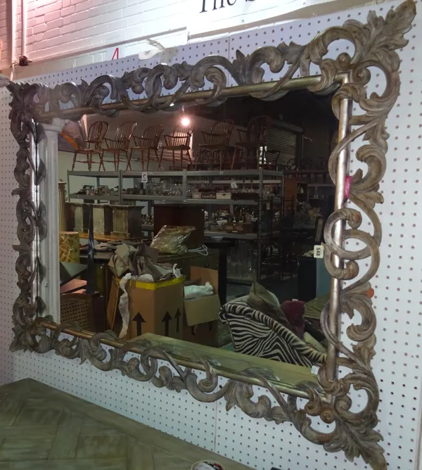 A George II style stained pine and silvered rectangular wall mirror, with foliate decoration, 150cm wide x 108cm high.  ROST