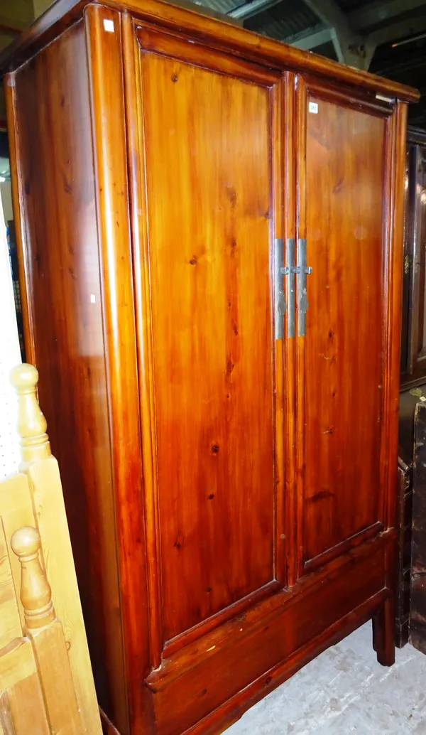 A 20th century softwood Asian two door wardrobe on block supports, 180cm wide x 210cm high. M10