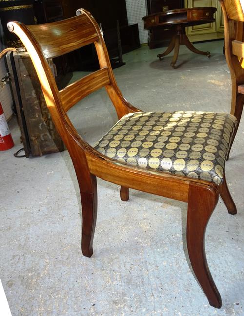 A set of four 19th century mahogany and rosewood banded bar back dining chairs, on sabre supports, (4).   E7