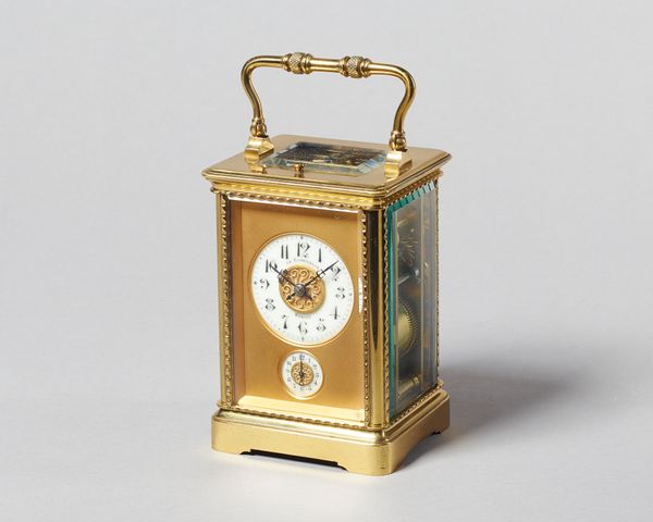 A French brass carriage clock Circa 1910In a corniche type case with decoration, the knopped engine turned handle above bevelled glass panels and push