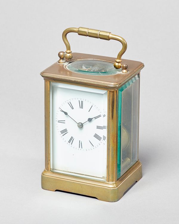 A French brass carriage clockCirca 1900In a corniche case with original silvered platform lever escapement, striking on a gong, with white enamel dial