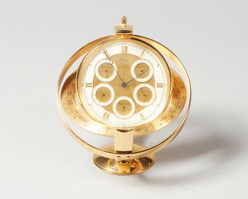 A Modern Swiss giltmetal world-time timepieceRetailed by AspreyMounted in a ring, the 5in. central dial with five subsidaries and with an outer world