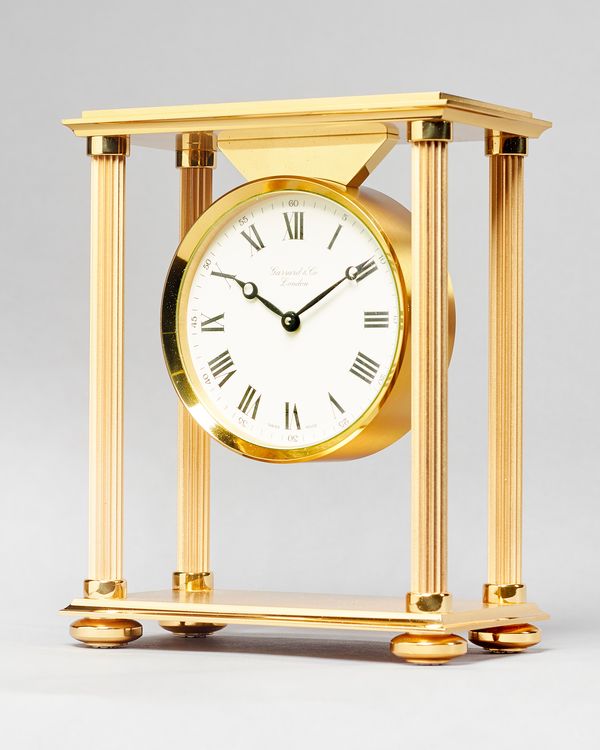 A Modern Swiss giltmetal portico quartz timepieceFor Garrard & Co, LondonThe rectangular top supported on four reeded uprights, on conforming plinth w