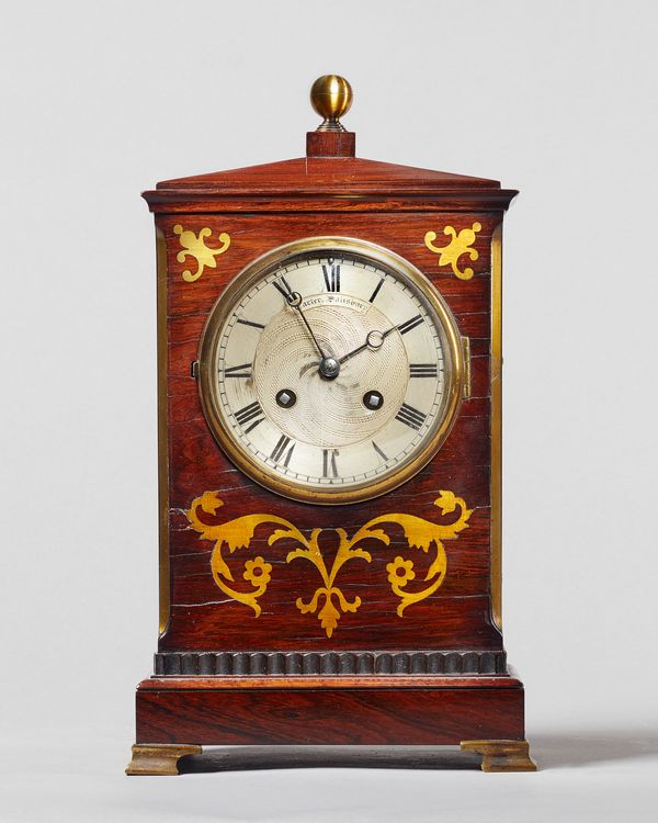 A rosewood and brass inlaid mantel clockRetailed by William Carter, Salisbury, circa 1850The slender chamfer topped case surmounted by a brass finial,