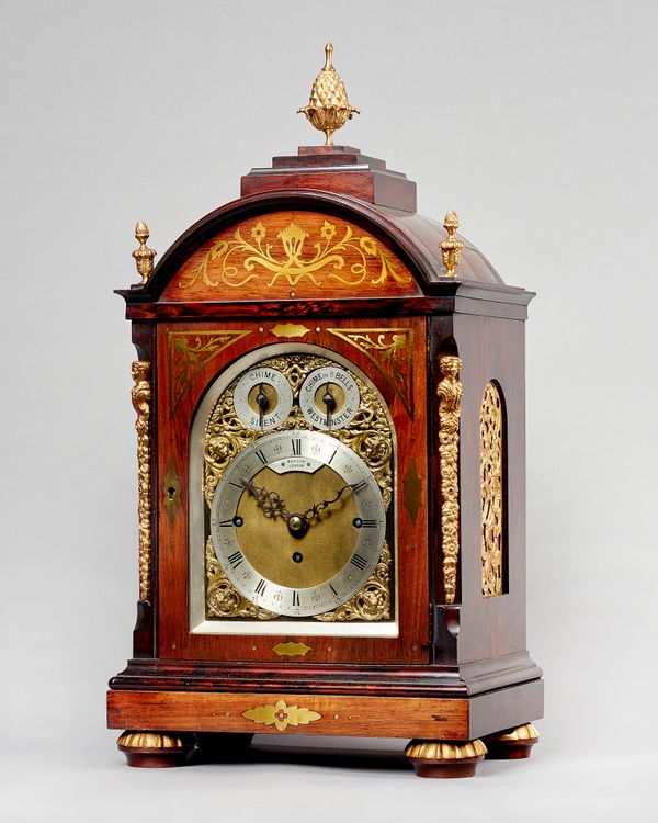 A Victorian rosewood and cut-brass inlaid three-train chiming mantel clockBy Benson, London, circa 1890The broken arched case surmounted by a stepped