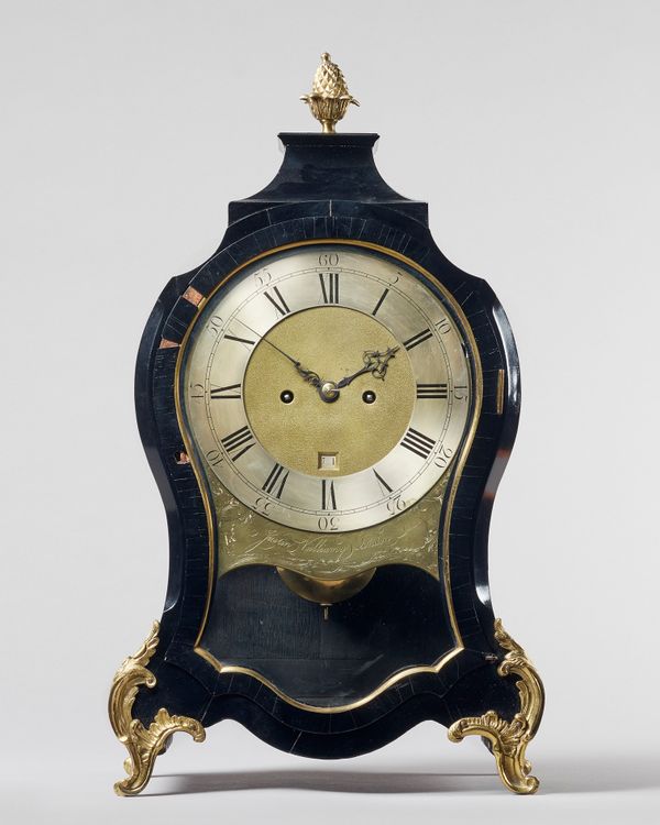 A George III ormolu-mounted ebonised balloon bracket clockBy Justin Vulliamy, London, circa 1770The shaped waisted case surmounted by a pineapple fini