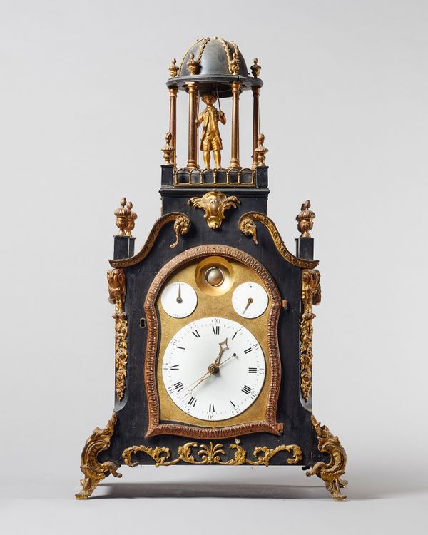 A George III ormolu-mounted ebonised quarter-striking automaton clock with moonphase, calendar and sweep centre seconds.The case surmounted by a man s
