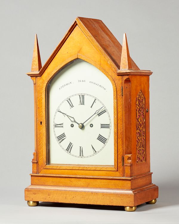 A Victorian gothic oak mantel clockBy Stedman, Godalming, dated 1846The arched case with two tapering front finials, above a glazed door, flanked to e