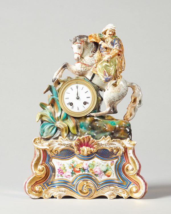 A French porcelain mantel clockIn the style of Jacob Petit, circa 1860 Modelled with an equestrian figure of an arab hunter, on a naturalistic base, o