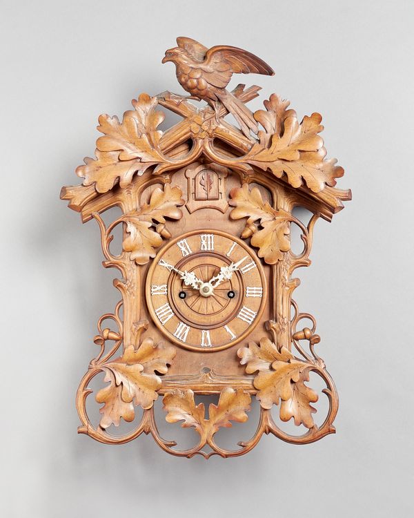 A Tyrolean carved walnut Cuckoo clockLast quarter 19th CenturyOf large form, the architectural case carved with oak leaves and acorns, surmounted by a