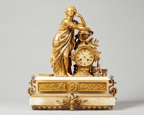 A French giltmetal and alabaster mantel clockMid 19th CenturyModelled with a female figure resting on a globe, with a drum-shaped case and movement, c