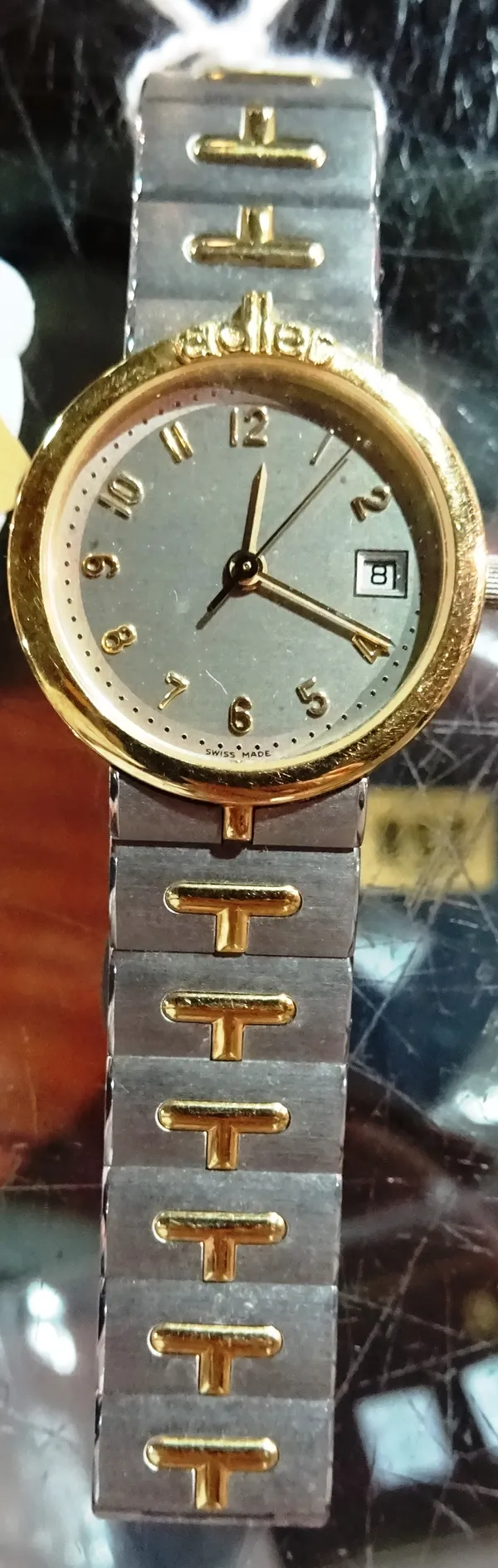 An Adler Quartz steel and gilt lady's bracelet wristwatch, the signed silvered dial with gilt Arabic numerals, centre seconds and with a calendar aper