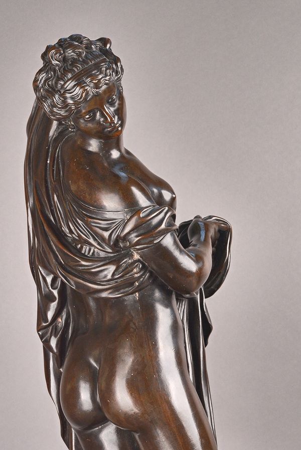 A Victorian style patinated bronze, cast as a semi-nude classical female figure, early 20th century, in a long flowing robe, on a circular base, unsig