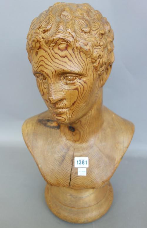 A pitch pine carved bust of a Romanesque male, 20th century, on a turned socle (50cm high) and one similar female bust (53cm high), (2).