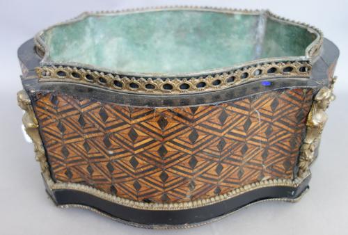 A Victorian parquetry inlaid wooden jardiniere, of shaped serpentine form, with twin handles, ormolu figural embellishments and a tin liner (43cm acro