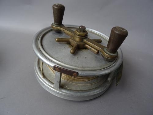 A Hardy 'Fotuna' 7 inch sea fishing reel, twin reverse taper handles on a brass bar, star drag and six screw brass foot, stamped marks, (a.f).  Illust