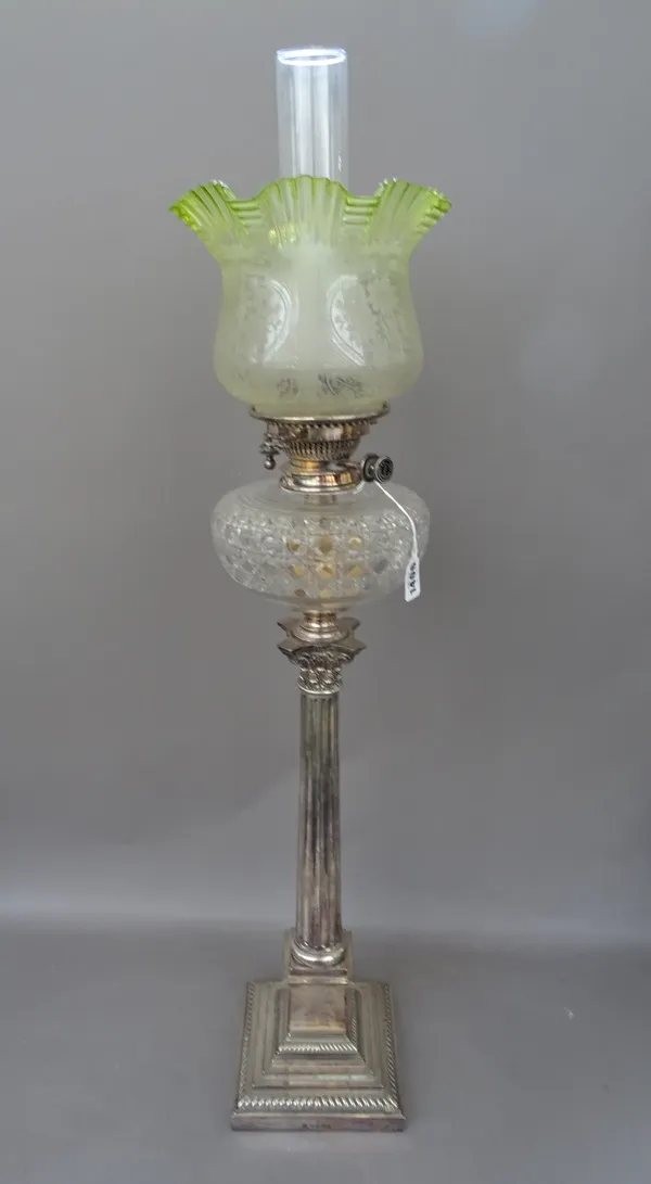 An Edwardian silver plated oil lamp of Corinthian column form, with a cut clear glass reservoir, Hinks Duplex burner and a later green foliate frosted