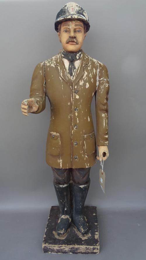 A French polychrome painted carved wooden 'Pompier' figure, early 20th century, on a square plinth, (a.f), 98cm high.