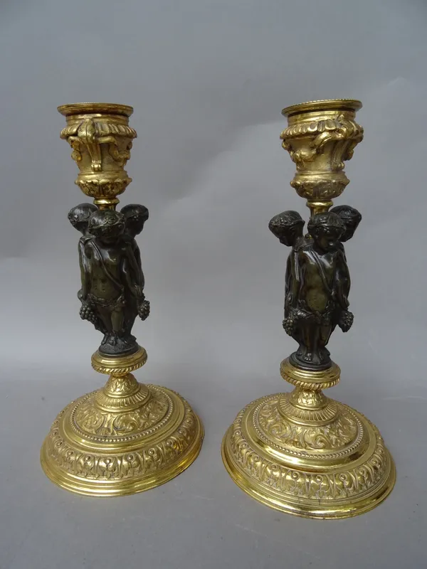 A pair of gilt metal and bronze mounted Regency style figural candlesticks, early 20th century, each with urn shaped sconce over a triform figural col