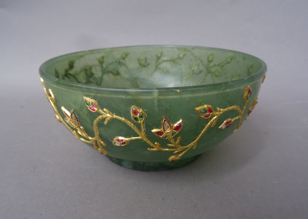 A gold and gem set inlaid jade bowl, India, early 20th century, decorated to the exterior with a floral band, 13.5cm diameter.  Illustrated