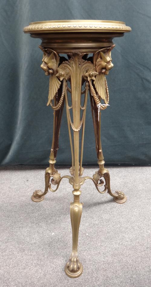 A French bronze tripod pedestal of Neo-Grecian style, circa 1860, with lions head masks united by pearl swags over three lion paw feet with rotating c