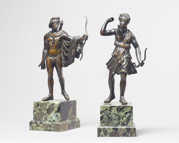 A pair of French patinated bronze figures of Diana and Apollo, 19th century, each raised on a green marble stepped rectangular plinth, 30cm high, (2).