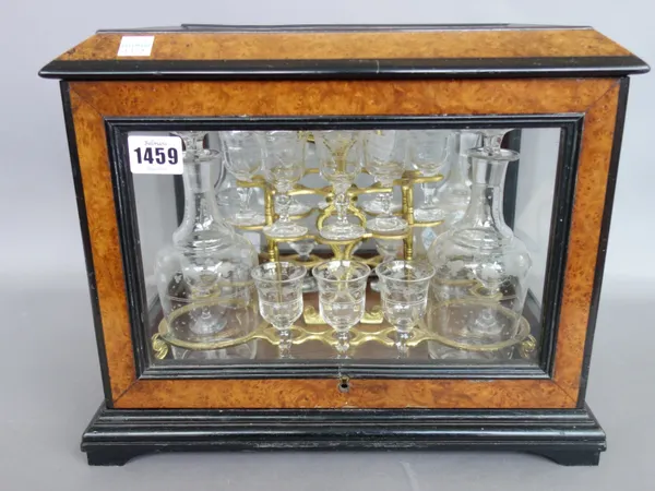 A burr walnut and ebonised decanter case, late 19th century, of glazed rectangular form, with hinged lid enclosing gilt metal mounted wooden tray and
