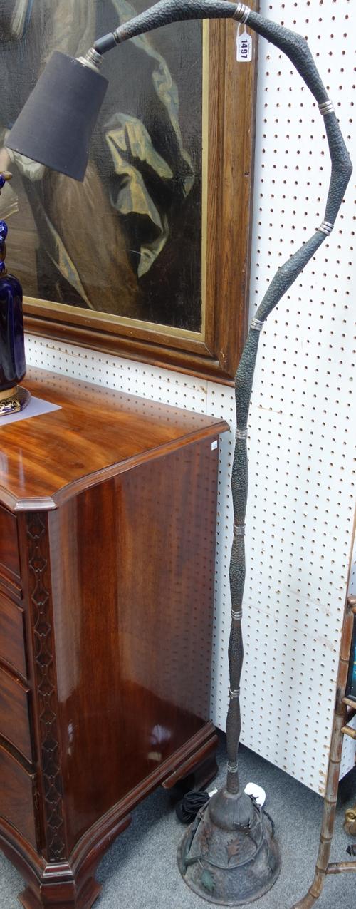 A copper coloured metal floor lamp in the manner of Edgar Brandt, of beaten sectional form with foliate embellished base, 168cm high.