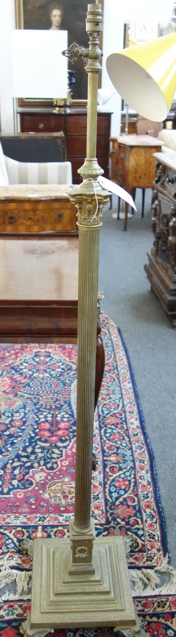 A Victorian style adjustable brass standard lamp, 20th century, of Corinthian column form, on four lion's paw feet.