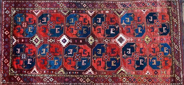 An Uzbek Karakalpak carpet, the madder field with six pairs of bold guls, each quarter section with a stylised dog, central line of stepped diamonds,