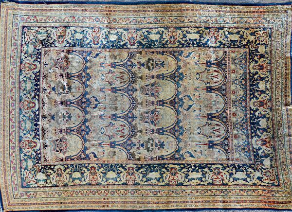 An antique North West Persian part silk rug, the indigo field with rows of arches bearing vases of flowers, a band to the top; an indigo palmette bord