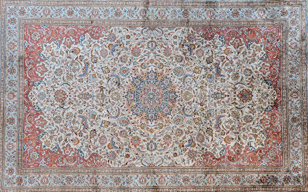 A fine Chinese silk rug of Esfahan design, the ivory field with an indigo roundel, intricate floral sprays, madder spandrels; a pale indigo palmette b