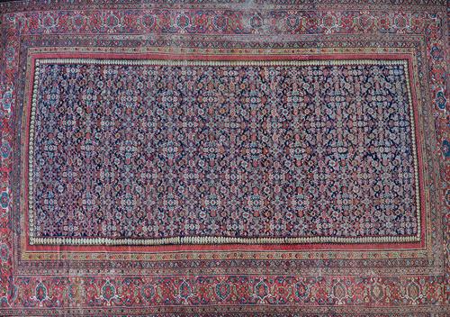 A Fereghan carpet, early 20th century, dark blue field with all over Herati design within a wide palmette main border and multiple guard strips, 328cm