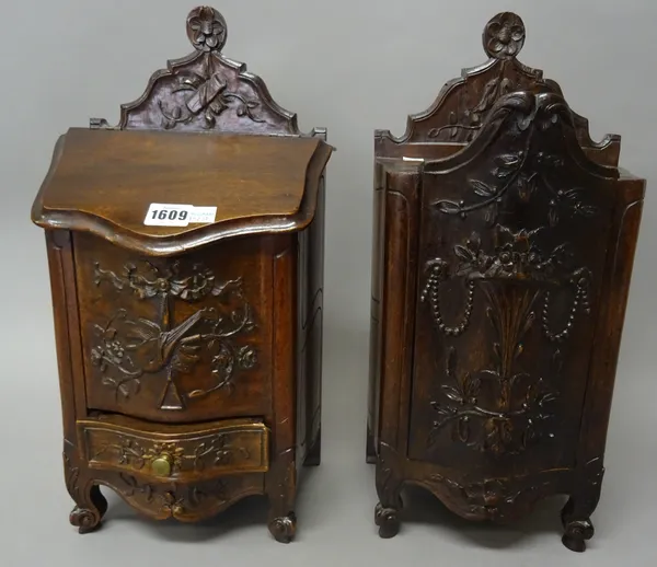 A near pair of French late 19th century walnut candle/salt boxes, with carved floral decoration, 22cm wide x 44cm high x 16cm deep.