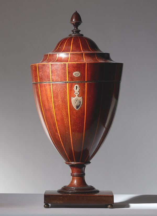 A Robert Adam style boxwood strung mahogany urn, second half of the 19th century, the lift top with acorn finial, enclosing an associated fitted inter