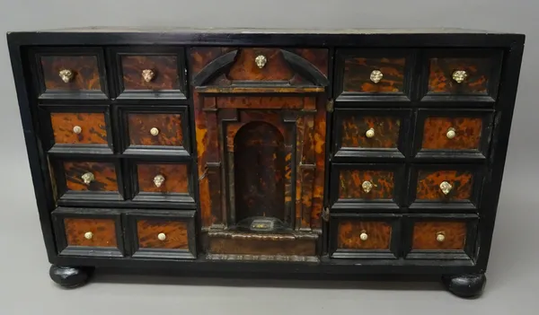 A late 17th century/early 18th century tortoiseshell, rosewood and ebonised table top cabinet, probably Anglo-Portuguese, the central door with broken
