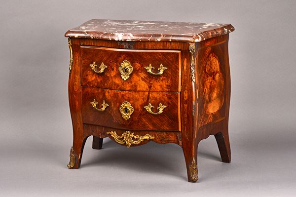 A diminutive Louis XV style commode, circa 1900, the serpentine marble top over a gilt metal mounted marquetry inlaid Kingwood and walnut bombé two dr
