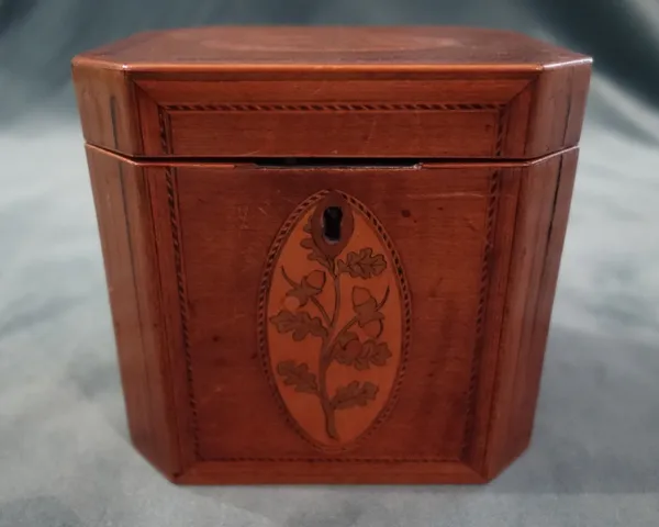 A George III marquetry inlaid harewood tea caddy, of canted rectangular form, with single lidded interior, 12.5cm wide x 11.5cm high x 10cm deep.