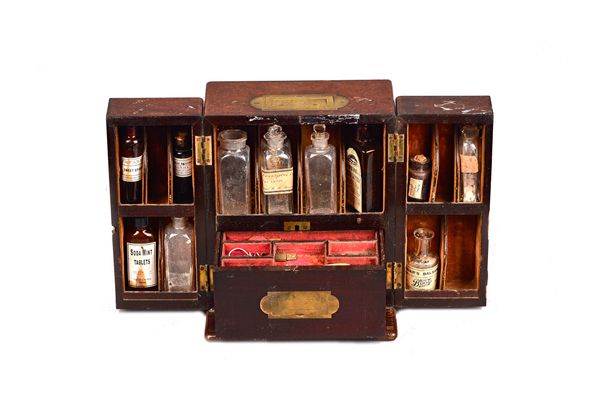 A George III brass mounted mahogany apothecary cabinet, the pair of fold-out doors enclosing a compartmentalised interior with bottles and fitted sing