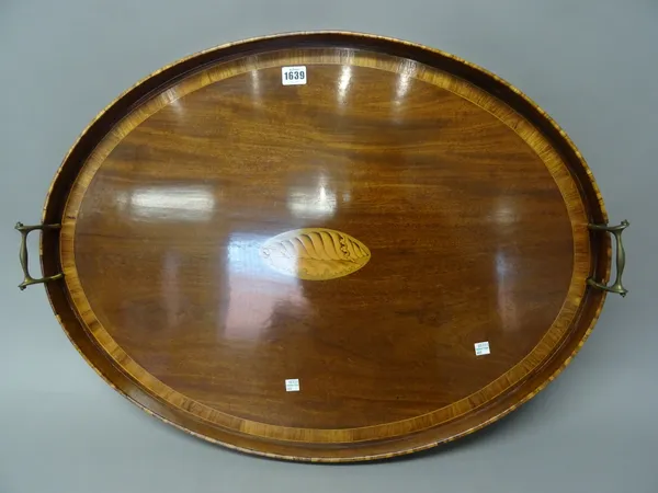 A George III conch shell inlaid tulipwood banded mahogany galleried oval serving tray, with brass loop handles, 76cm wide x 57cm deep x 4.5cm high.