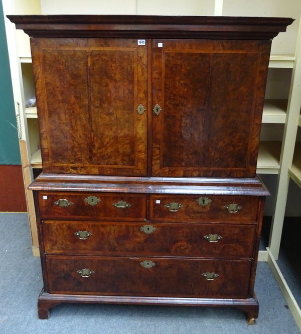 A George I chevron banded figured walnut cabinet on chest, the pair of doors enclosing a fitted interior over two short and two long graduated drawers