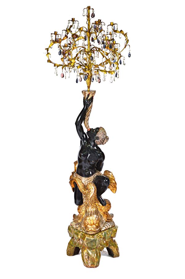 A 20th century Blackamoor candelabra, the gilt metal fourteen branch light on a cornucopia type mount, being held by a seated Blackamoor female riding